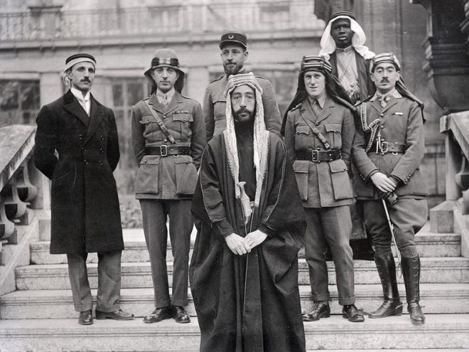 L'Emiro Faisal in primo piano e TE Lawrence il quarto da sinistra nella fila dietro durante i colloqui di pace a Versaille nel 1919 [Foto da Wikipedia]